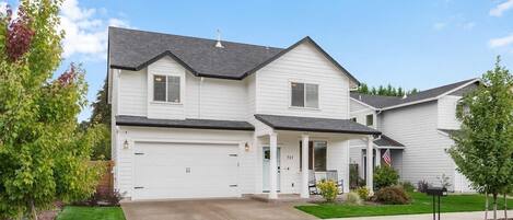 The welcoming front of the house with two rockers on the porch looking at a park and wineries. The sea-foam door welcomes you into your wine getaway weekend!