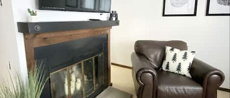 Smart TV over the fire place with remote controlled LED candles to fit the vibe.