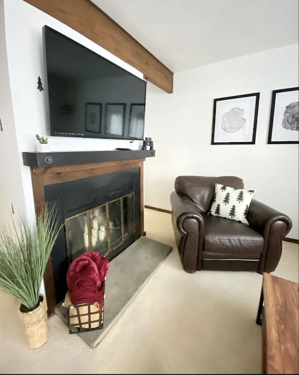 Smart TV over the fire place with remote controlled LED candles to fit the vibe.