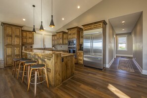 Fully stocked kitchen with large fridge and gas stove