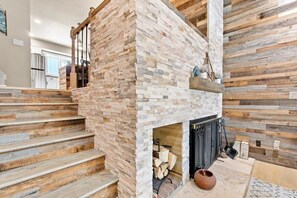 Cozy indoor wood fireplace, and stairs to the second floor of the home