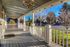Covered front porch with chandelier lighting.