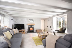 Beach Cottage, St Agnes. Ground floor: Sitting room with comfortable sofas, a wood burning stove and Smart television with Sky and DVD player