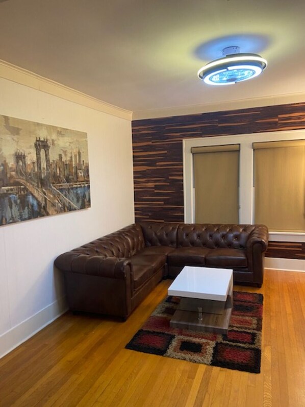 Living room with leather furniture  and 75 inch curved Samsung smart TV