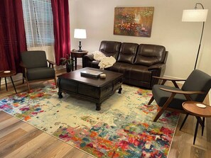 Front room leather couch has two recliners.