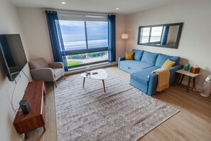 Living room with pull out queen sofa bed, smart TV + roomy living space for a family game night!