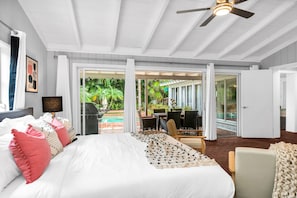 The master suite is a large bedroom with an en-suite bathroom, a large walk-in closet, a smart HDTV, and direct access to the outdoor pool deck.