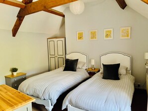 The second bedroom with its sumptuous beds and exposed beams.