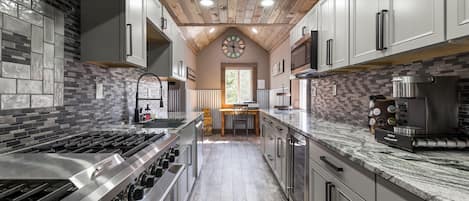 This Galley Kitchen's gleaming granite countertops and Chef's Stove will ignite your culinary creativity.