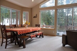 Large dining table for family meals surrounded by views of the nearby pines.