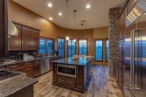 The fully stocked kitchen features an island with a large pull out microwave.