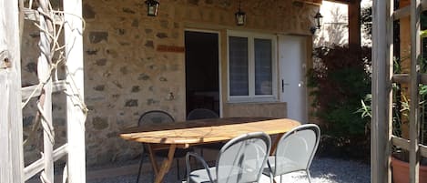 Terrasse couverte exposée Sud avec table d'extérieure et chaises