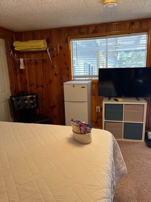 Side chair, fridge, storage cubbies, welcome basket, and 43" TV