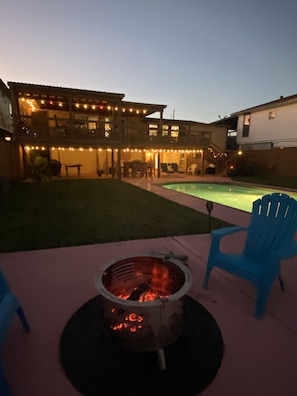 Fire pit with view of property and lights at nite 