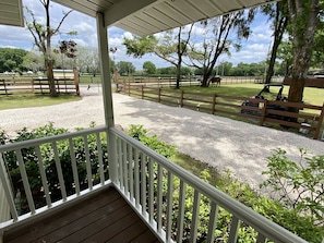 Front porch view and gated/fenced guest parking area. 