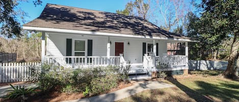 Front view of home nestled between gorgeous oaks trees & 1 block to the beach