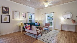 Spacious living area featuring original hardwood floors and bead board ceiling