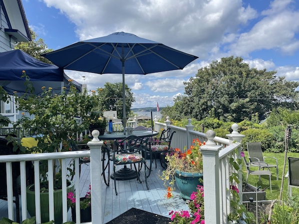 Lovely view of the ocean harbor from back deck. Chairs and wicker slider.