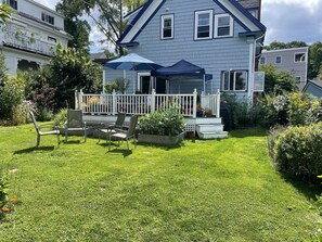 Backyard of house with deck. There is also a large lower garden to the right.