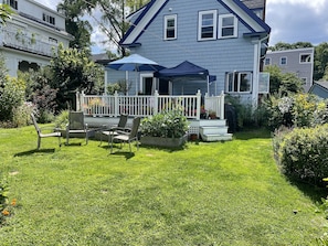 Backyard of house with deck. There is also a large lower garden to the right.