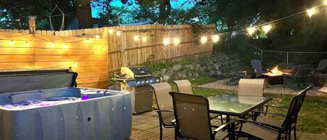 Secluded outdoor fire pit space. Patio with grill and 6 person hot tub. 