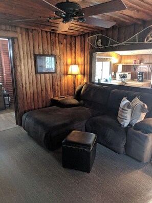 Cabin 5 living room with sofa that reclines on one side