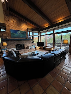 Floor to cathedral ceiling designer fireplace anchors the large living room