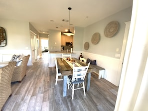 The dining table seats 4, with additional seating at the bar