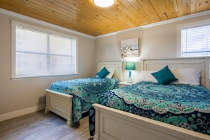 Bedroom 2, with twin and full beds, closet and dresser. View of pool.