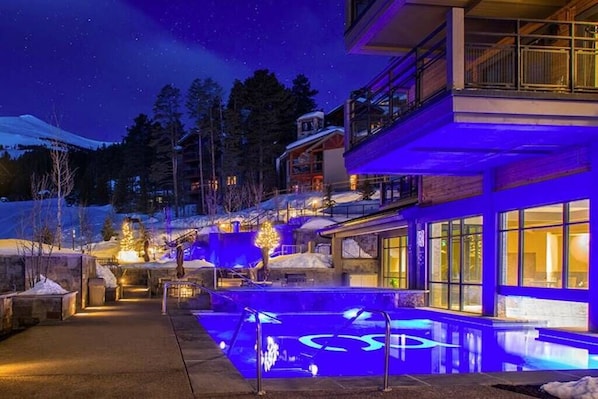 Heated indoor-outdoor pool area. Hot tubs around it. 