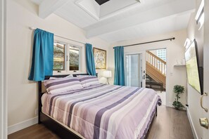 Primary bedroom has a king bed & a flat panel tv.