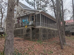 Screend in porch has new wooden swing, fold out chairs, table, bar height chairs