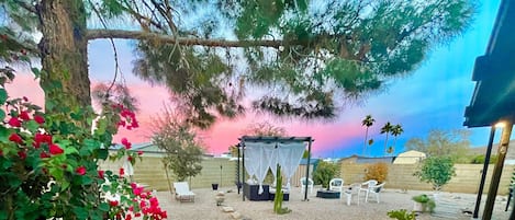 The back yard with pergola, couch and fire pit with a mountain view