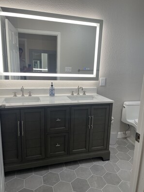 Remodeled bathroom,double vanity, lighted mirror, new tile floor, paint
