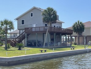 Side view showing large waterfront lot, palm trees, kayaks. Room to spread out