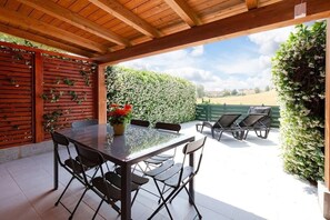 Private patio with outdoor furniture, barbecue and sun loungers