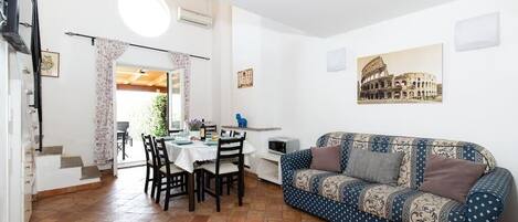 Living area with dining table, fireplace, double sofa bed and TV with Netflix.