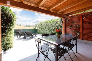 Private patio with outdoor furniture and barbecue