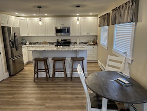 Full kitchen with seating at bar.