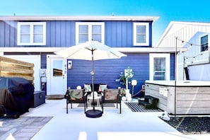 Back patio of duplex home w/ hot tub, fire pit, sitting area and grill