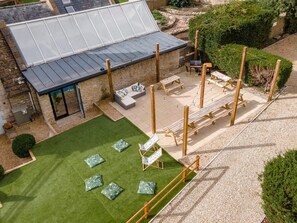 Large outdoor social space with terraced seating area and barbecue for al fresco dining