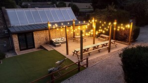 Large outdoor social space with terraced seating area and barbecue for al fresco dining