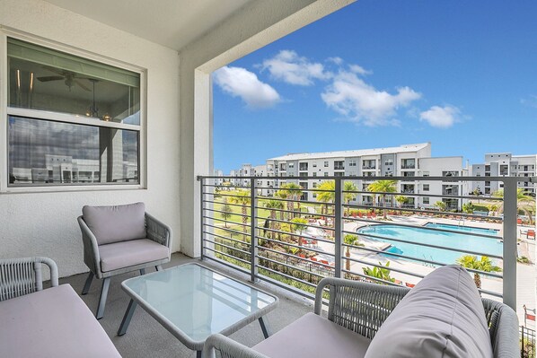 Chic private balcony of the condo in Kissimmee Florida - Enjoy the pool view from the comfort of balcony - Panoramic views of the surrounding area - Cozy outdoor retreat with seating