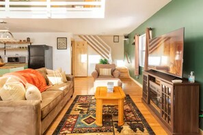 The comfy and luxurious living room with a fireplace to cozy up & watch a movie.