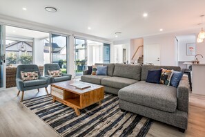 Bright and airy open-plan living area with Hamptons-inspired décor and a cosy gas fireplace.
