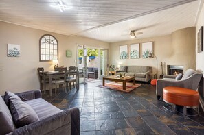 Living room with a fire place and a private patio with an outdoor kitchen. 