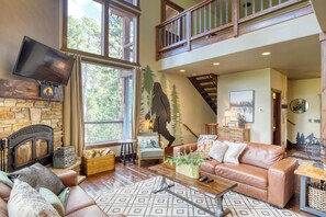 Main floor living room with wood burning fireplace and flat screen TV