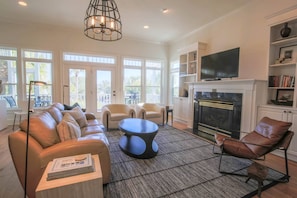 The living room features access to the screened porch and views of the Ocean Point community pool.