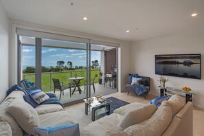 Spacious light-filled living area opening to outdoor balcony 