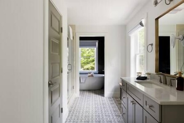 First floor owner's suite bathroom with plush towels and bathroom essentials